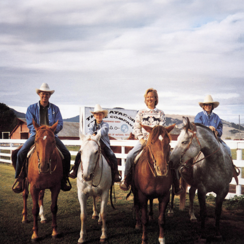 A photo of Charles, Chase, Liz and Elizabeth Koch, all seated on horseback in front of the sign for Matador Cattle Company.